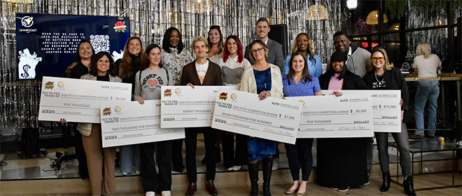 The MI Tribe pitch winners pose for a picture with their giant grant checks.