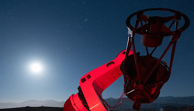 An optomechanical instrument is pointing up at a starry sky, collecting data about space.
